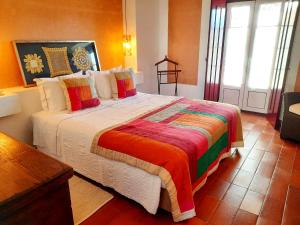 um quarto com uma cama grande e um cobertor colorido em Naturarte Campo - Duna Parque Resorts & Hotels em São Luis