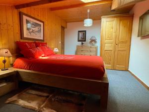 ein Schlafzimmer mit einem Bett mit roten Kissen in der Unterkunft Appartement Les Gets, 3 pièces, 8 personnes - FR-1-623-72 in Les Gets