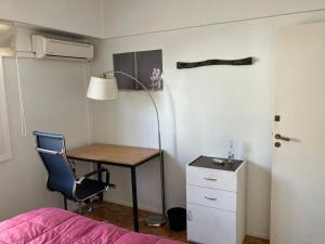 Dormitorio con escritorio, cama y lámpara en Habitación individual en departamento compartido, barrio Recoleta en Buenos Aires