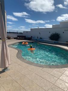 una piscina con 2 personas en el agua en Villa Linda, en Playa Blanca