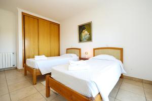 una camera da letto con due letti con lenzuola bianche di B80 - Gideon Albasol 2 Bed Apartment in Lagos a Lagos Altre 63 foto