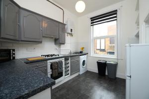 una cocina con electrodomésticos de acero inoxidable y una ventana en Spacious 3 Bedroom Apartment- Crouch End, en Londres