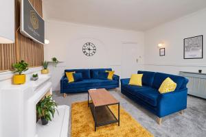 a living room with two blue couches and a table at Spacious 3 Bedroom Apartment- Crouch End in London