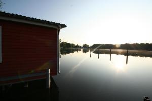 a building on a body of water with the sun setting at Cour De Berlin in Fürstenberg