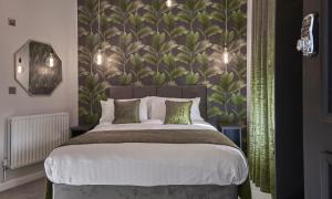 1 dormitorio con 1 cama grande y papel pintado frondoso en Home @ 2 Tancred Road en Liverpool
