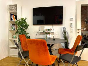 comedor con mesa y sillas naranjas en Premium Apartment with Terrace, A/C, FREE WiFi and NETFLIX en Viena