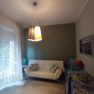 a living room with a white couch and a light fixture at Appartamento Via Dei Glicini in Laigueglia