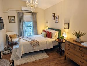 1 dormitorio con cama y lámpara de araña en Suites On King, en Niagara on the Lake