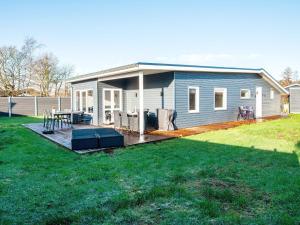 ein blaues Haus mit einer Terrasse mit einem Picknicktisch in der Unterkunft Two-Bedroom Holiday home in Børkop 9 in Egeskov