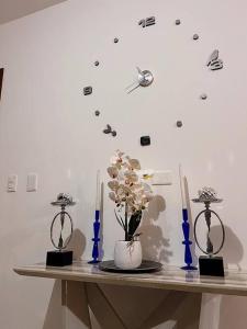 une table avec deux bougies et une horloge sur un mur dans l'établissement Outstanding Pent House w/Jacuzzi, à Santiago de los Caballeros