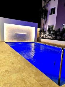 uma piscina azul em frente a uma casa em Outstanding Pent House w/Jacuzzi em Santiago de los Caballeros