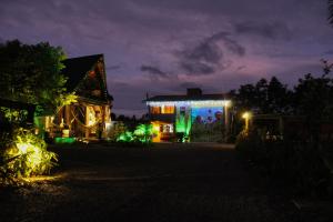 a house lit up at night with green lights at Pousada Rancho Alvorada in Praia Grande