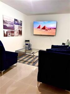 uma sala de estar com um sofá e uma televisão na parede em Outstanding Pent House w/Jacuzzi em Santiago de los Caballeros