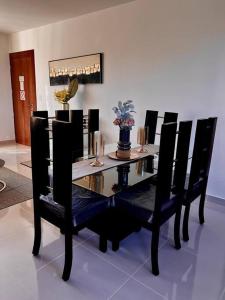 a black dining room table with black chairs and candles at Magnificent Pent House w/Jacuzzi in Santiago de los Caballeros