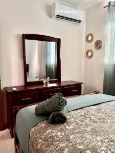 a bedroom with a bed with a dresser and a mirror at Magnificent Pent House w/Jacuzzi in Santiago de los Caballeros +22 photos