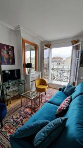 - un salon avec un canapé bleu et une table dans l'établissement Cocosmann, à Paris