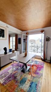 - un salon avec une table et des chaises sur un tapis dans l'établissement Cocosmann, à Paris