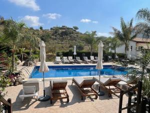 una piscina con tumbonas y sombrillas en SOFROS VALLEY HILLS CHALET, en Ayios Mamas