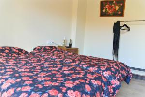 a bedroom with a bed with a floral comforter at Casa Bienvenida - La Fallera in Carcagente