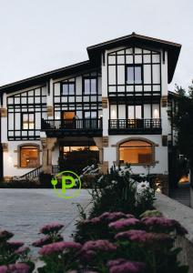 a house with a green logo in front of it at Bidaia Boutique Hotel in San Sebastián