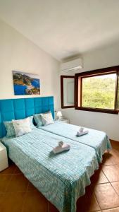 a bedroom with a blue bed with two towels on it at Casa Paradiso in Costa Paradiso +48 photos