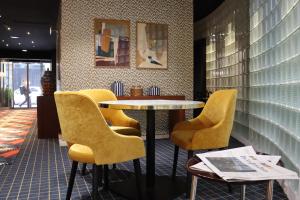 een restaurant met gele stoelen en een tafel in een kamer bij Le Pergolèse Paris Champs Elysées in Parijs