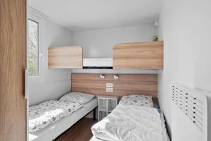 una piccola camera con 2 letti e una scrivania di First Camp Hasmark Camping Resort & Cottages a Otterup