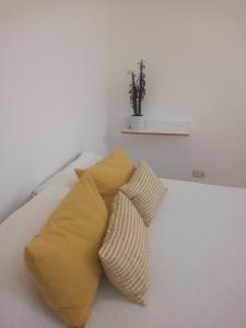 2 almohadas amarillas sentadas en una cama blanca en Amarello en Gualeguaychú
