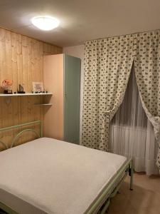 a bedroom with a bed and a cabinet and curtains at Sulle piste da sci in Abetone