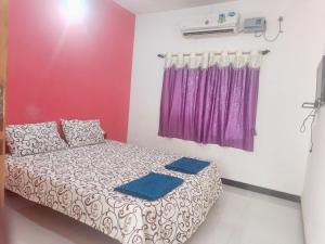 a bedroom with a bed and a purple curtain at Acharekar's Home stay - Adorable AC and Non AC Rooms with free Wi-Fi in Malvan