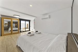 a white bedroom with a large white bed in a room at Villa Atlantico - Villasexperience in Arrecife