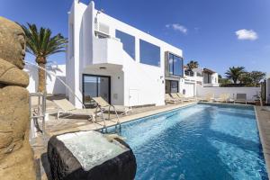 a villa with a swimming pool and a house at Villa Atlantico - Villasexperience in Arrecife
