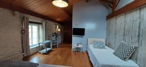 salon z kanapą, stołem i telewizorem w obiekcie "LA ROCHELLE LODGE" Chambres d'Hôtes w mieście Sainte-Soulle