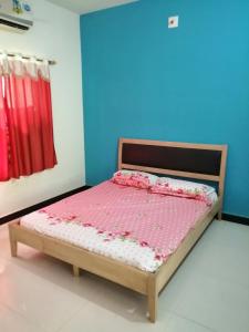 - une chambre dotée d'un lit avec des draps roses et blancs dans l'établissement Acharekar's Home stay - Adorable AC and Non AC Rooms with free Wi-Fi, à Malvan