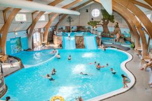 - un groupe de personnes dans une piscine d'un parc aquatique dans l'établissement First Camp Hasmark Camping Resort & Cottages, à Otterup