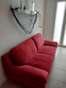 A 2 passi dal mare في Scardovari: أريكة حمراء في غرفة المعيشة مع شبكة
