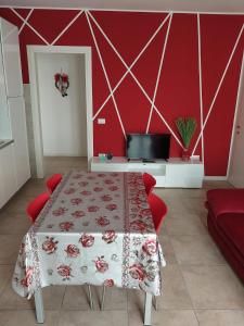 Zimmer mit einem Tisch und einer roten Wand in der Unterkunft A 2 passi dal mare in Scardovari