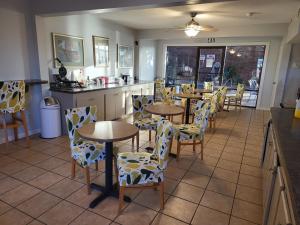 ein Restaurant mit Tischen und Stühlen in einem Zimmer in der Unterkunft Blue Ribbon Inn and Suites in Sallisaw