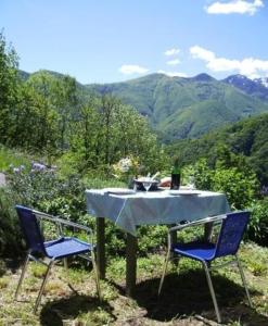 een tafel en twee stoelen met een tafel en bergen bij Casa Cresmino in Cavigliano