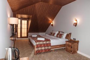 ein Schlafzimmer mit einem Bett und einer Holzdecke in der Unterkunft Mount Way Hotel in Shahdag + 32 Fotos