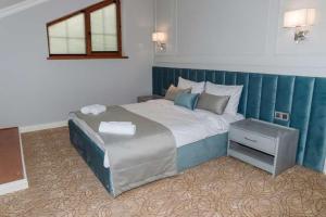 ein Schlafzimmer mit einem großen Bett mit blauem Kopfteil in der Unterkunft Mount Way Hotel in Shahdag