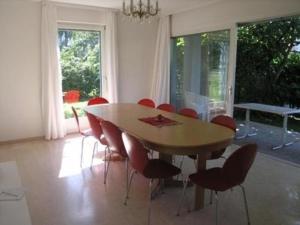 jadalnia z drewnianym stołem i czerwonymi krzesłami w obiekcie Casa Irma w mieście Ascona