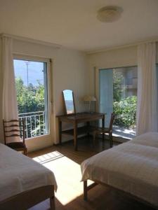sypialnia z 2 łóżkami, biurkiem i oknem w obiekcie Casa Irma w mieście Ascona