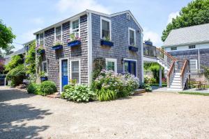 uma casa com portas azuis e flores num quintal em The Lightkeeper’s Inn em Edgartown