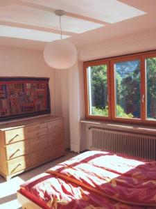 Schlafzimmer mit einem Bett, einer Kommode und Fenstern in der Unterkunft Casa Nespole, Familiennest mit Seesicht in Minusio