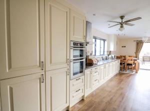 cocina con armarios blancos y ventilador de techo en Caban Nant Ddu, en Nantmel