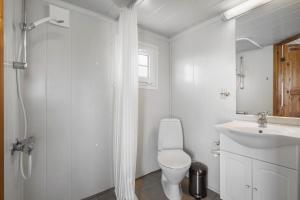 a white bathroom with a toilet and a sink at First Camp Klim Strand - Nordvestkysten in Fjerritslev