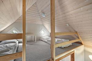 Cette chambre dispose de 2 lits superposés et de plafonds en bois. dans l'établissement First Camp Klim Strand - Nordvestkysten, à Fjerritslev