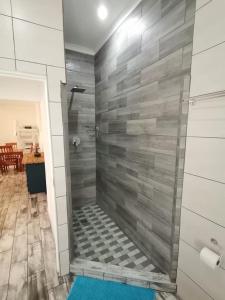 y baño con ducha y pared de azulejos. en 34 Hornbill Street, en St Lucia