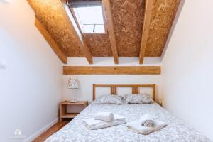 1 dormitorio con 1 cama con toallas en Casa da Torre - BBQ and Terrace en Santa Cruz